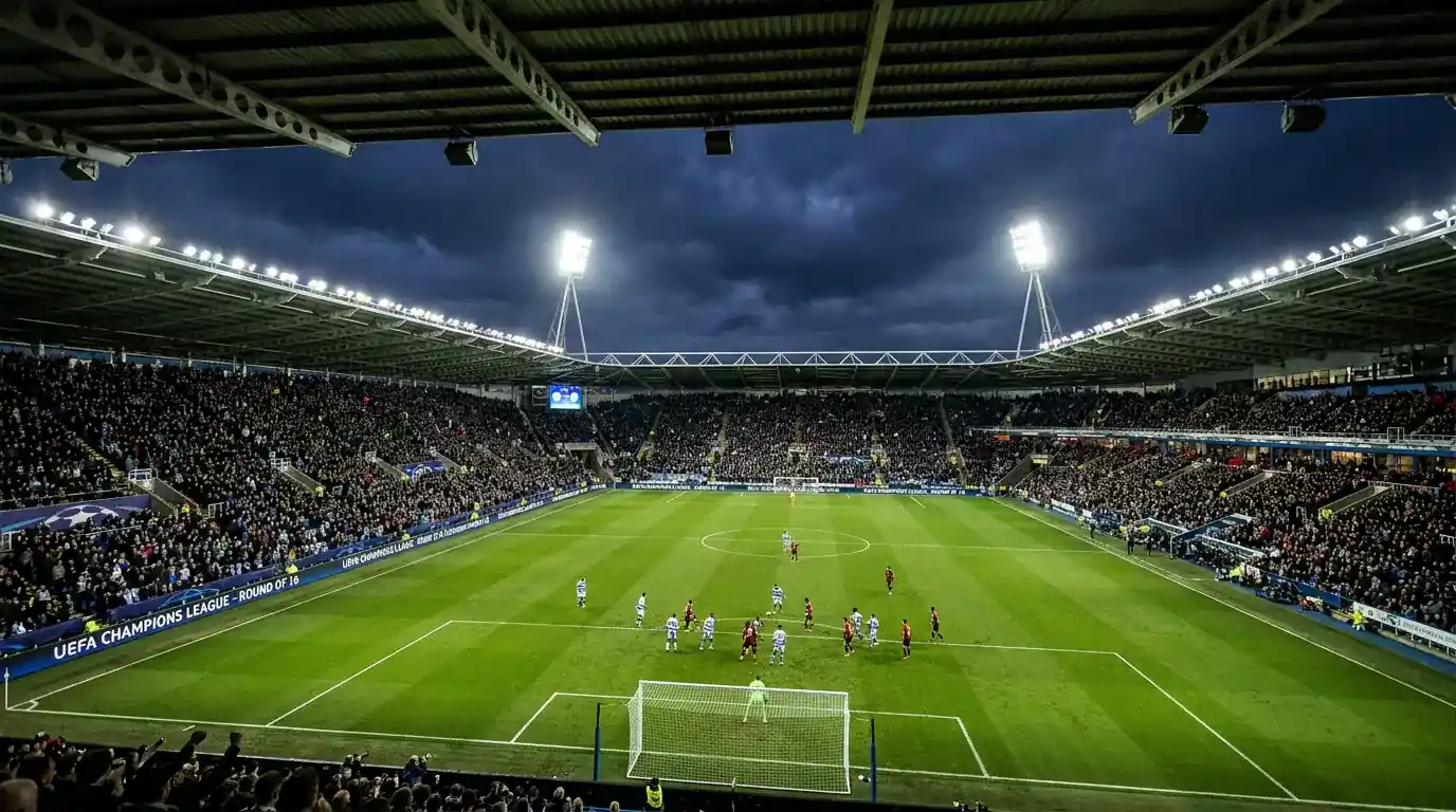 Stadio europeo illuminato durante una partita serale di UEFA Champions League con il logo della competizione