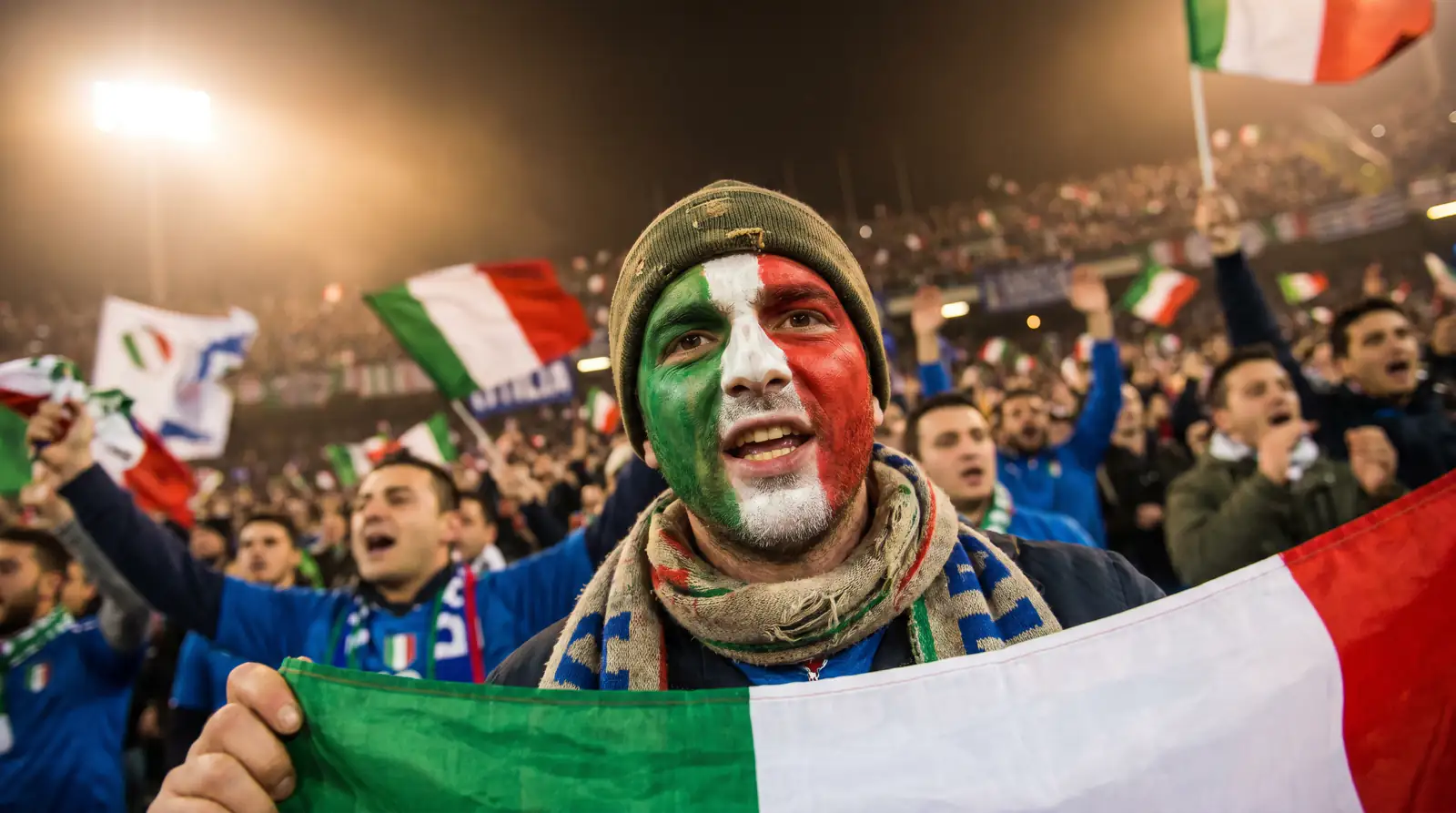 Tifoso italiano con la bandiera tricolore allo stadio durante una partita degli Azzurri